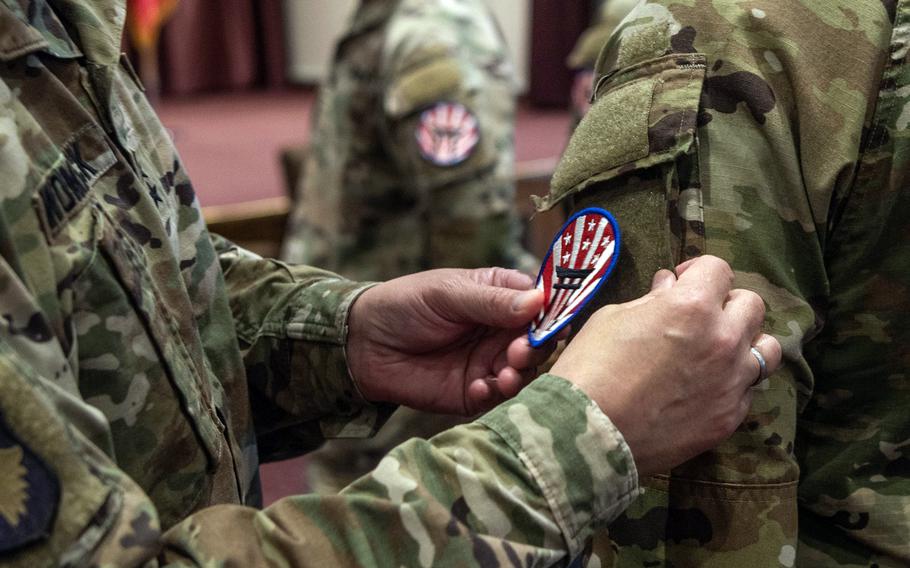 The commander of U.S. Army Japan, Maj. Gen. David Womack, presents soldiers with their new organization patches during a ceremony in the Officers' Club at Yokota Air Base, Japan, May, 20, 2024.