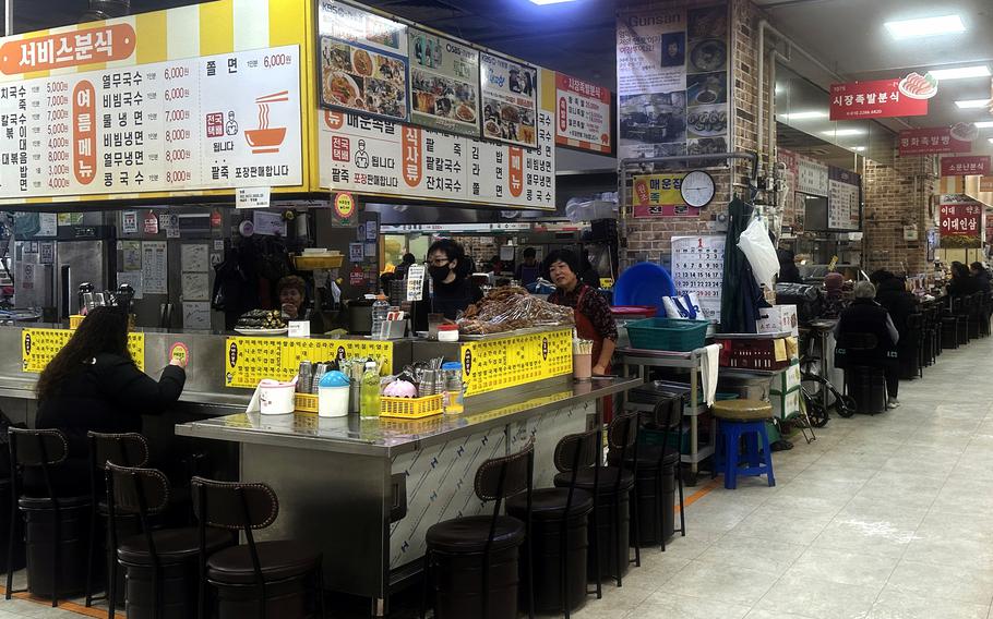 Food stalls at Gunsan Public Market near Kunsan Air Base, South Korea, serve everything from hot noodle dishes to prepared lunch trays. 