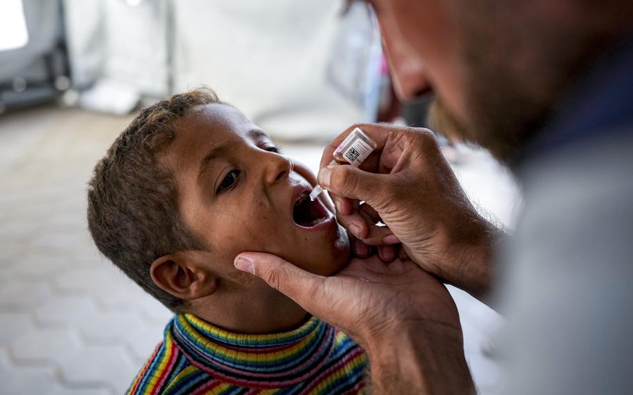 A health worker administers a polio vaccine to a child