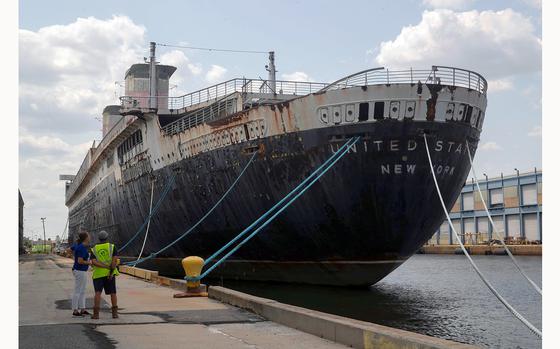 Susan Gibbs and Jorge Gonzalez look up at the SS United States ocean liner at Pier 82 in Philadelphia on Friday, July 23, 2021. It is the 25th anniversary of Americaís Flagshipís arrival in Philadelphia. The ship was the fastest passenger ship built and the largest ever made in the U.S., according to the SS United States Conservancy. Gibbs grandfather, William Francis Gibbs, was the self-taught naval architect and marine engineer of the ship. (Heather Khalifa/The Philadelphia Inquirer/TNS)