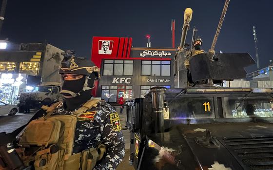 Iraqi security forces stand guard in front of Kentucky Fried Chicken restaurant in Baghdad, Wednesday, June 5, 2024. The recent protests — apparently organised by supporters of Iran-backed, anti-American militias in Iraq — reflect surging anger against the United States, Israel’s top ally, over the war in Gaza. (AP Photo/Ali Jabar)