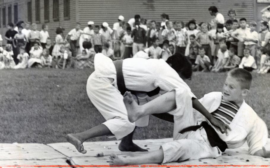 Narimasu Elementary School students Fred Snead (left) and Gary Martin wrestle on the mat in a judo match, part of the school’s Junior Olympics. The school’s sixth graders who had just finished studying in Greece — the nation where the Olympic Games originated — staged an Olympics of their own. Snead won the bout and the judo title at the Junior Olympics.