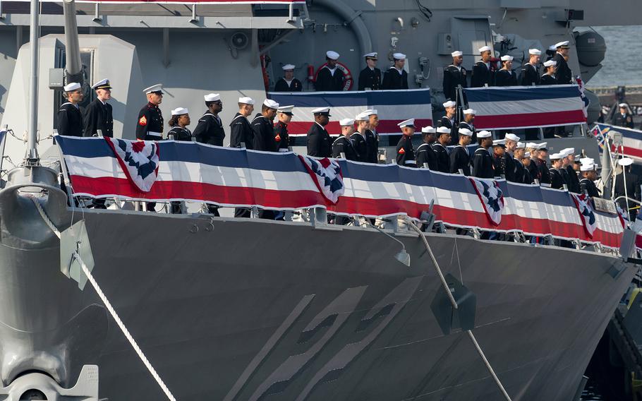 The crew lines the deck of the USS John Basilone.