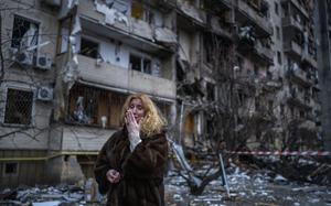 A woman reacts next to her house following a rocket attack the city of Kyiv, Ukraine.