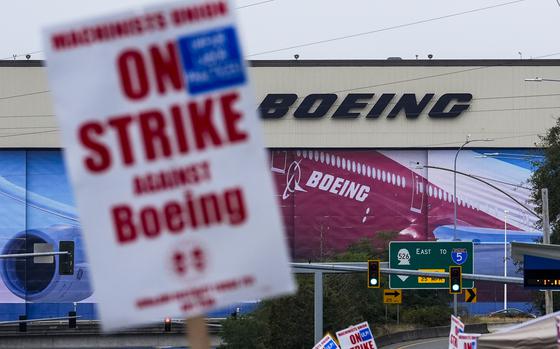 Boeing workers wave picket signs as they strike after union members voted to reject a contract offer, Sunday, Sept. 15, 2024, near the company's factory in Everett, Wash. (AP Photo/Lindsey Wasson)