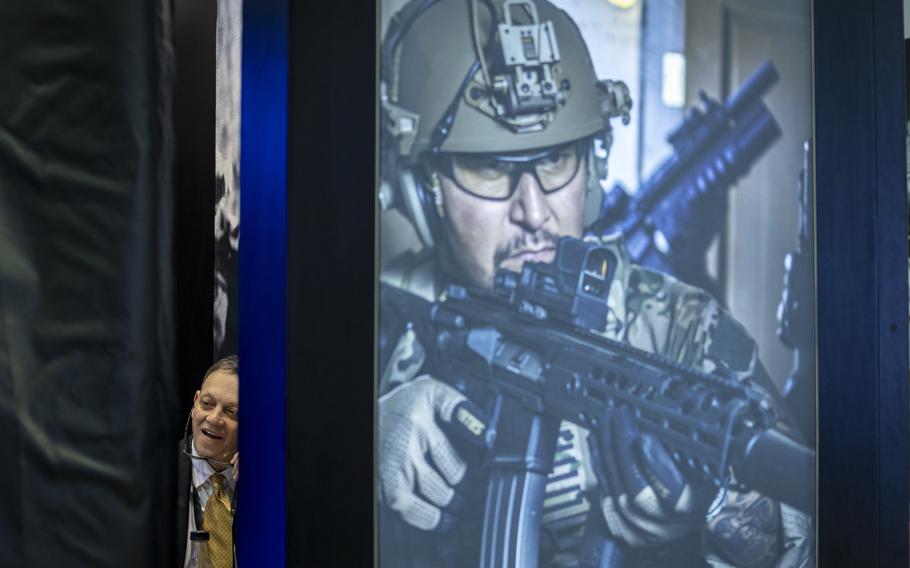 A man smiles inside a conference booth