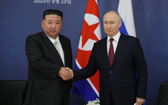 This pool image distributed by Sputnik agency shows Russian President Vladimir Putin, right, and North Korea's leader Kim Jong Un shaking hands during their meeting at the Vostochny Cosmodrome in Russia's Amur region on Sept. 13, 2023. (Vladimir Smirnov/Pool/AFP/Getty Images/TNS)