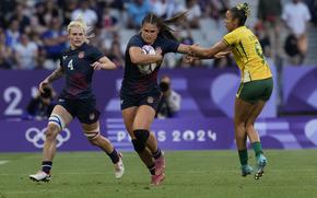 The USA’s Sammy Sullivan, left, runs with Ilona Maher, center, who gets past the tackle of Brazil's Gabriela Lima during the women's Pool C Rugby Sevens match between the United States and Brazil at the 2024 Summer Olympics, in the Stade de France, in Saint-Denis, France, Sunday, July 28, 2024. 