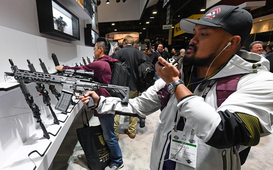 Paulo Rubio of Canada looks at a short-barreled rifle at the Sig Sauer booth at the 2018 National Shooting Sports Foundation’s Shooting, Hunting, Outdoor Trade (SHOT) Show at the Sands Expo and Convention Center on Jan. 23, 2018, in Las Vegas, Nev. 