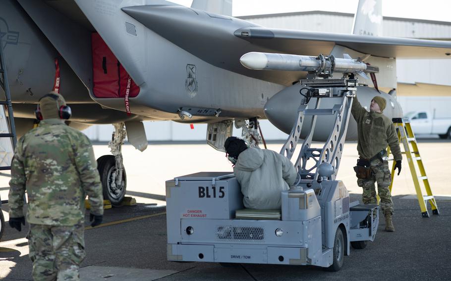 Weapons loaders at Kadena Air Base load a trainer missile onto an F-15EX.