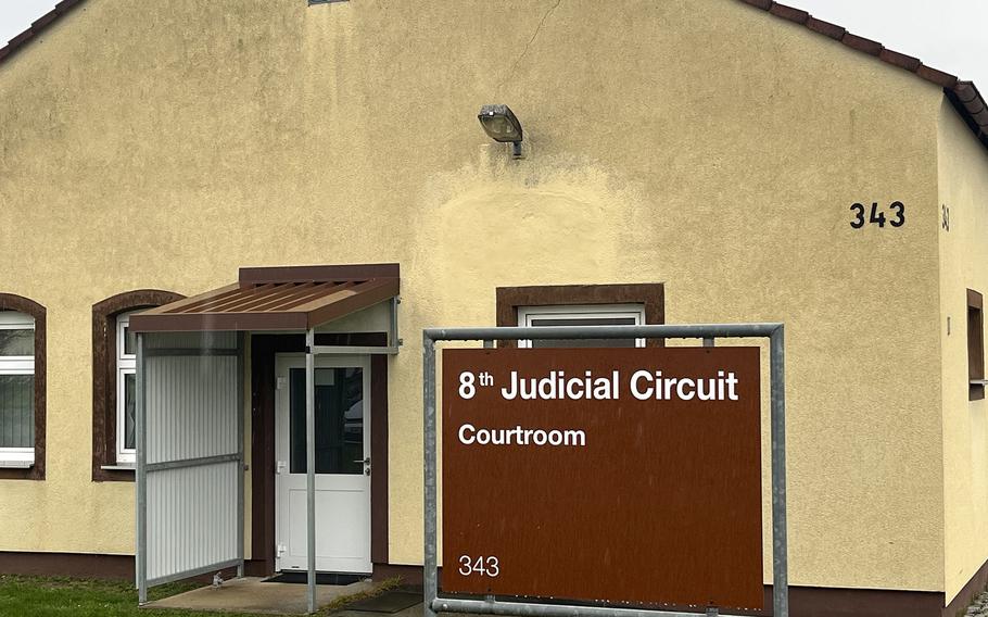 A sign for the 8th Judicial Circuit courtroom in front of a building.