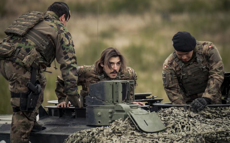 A tank crew from Switzerland enters its Leopard 2.