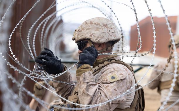 A U.S. Marine with 1st Combat Engineer Battalion, 1st Marine Division, adjusts concertina wire along the southern border wall near San Ysidro, Calif., Jan. 27, 2025. U.S. Northern Command is working together with the Department of Homeland Security with the emplacement of physical barriers to add additional security that will curtail illegal border crossings. (U.S. Marine Corps photo by Lance Cpl. Caleb Goodwin)