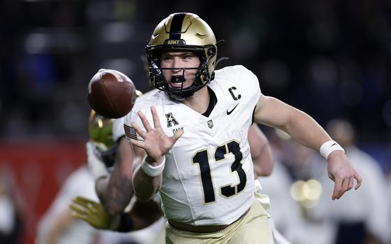 A football is seen in front of Army Black Knights quarterback Bryson Daily, whose fingers it just left.