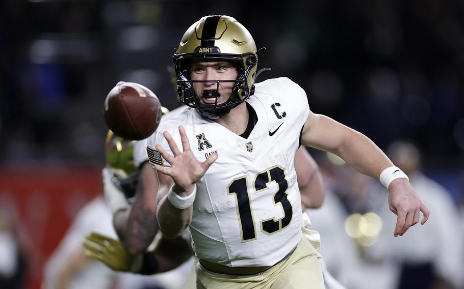 A football is seen in front of Army Black Knights quarterback Bryson Daily, whose fingers it just left.