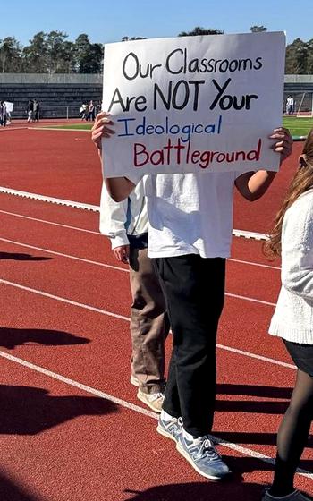 Students hold up protest signs