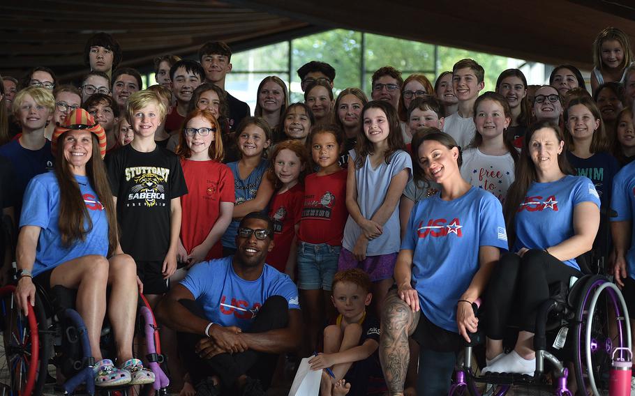 U.S. Paralympic swimmers in front, from left, Christie Raleigh Crossley, Jamal Hill, Army Sgt. 1st Class Elizabeth Marks and Leann Smith pose with members of the Stuttgart Piranhas swim team Aug. 20, 2024, at a pool in Sindelfingen, Germany. Forty swimmers came out to an open practice to meet the U.S. Paralympic swim team ahead of the 2024 Paralympic Games in Paris.