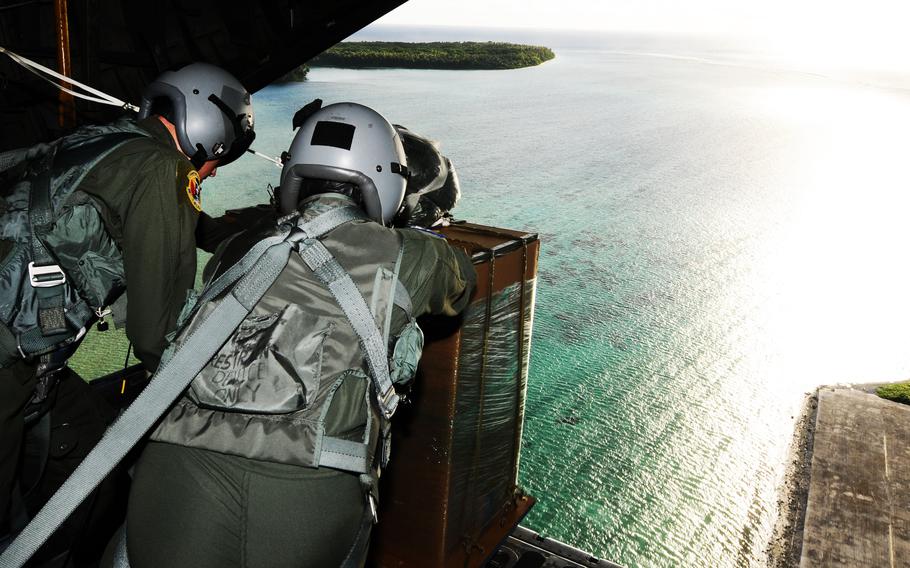 C-130 loadmasters from the 36th Airlift Squadron, Yokota Air Base, Japan, begin air drop delivery of a palle