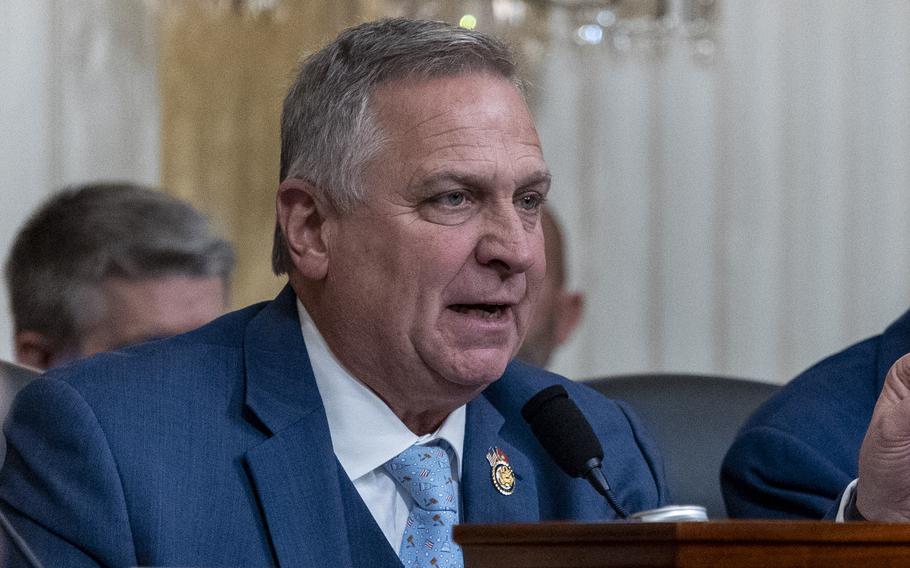 A congressman wearing a blue suit speaks into a microphone during a House hearing.