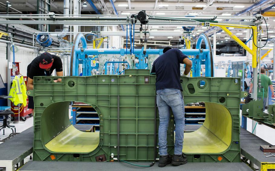 Employees work on the assembly line at the Boeing Defense, Space & Security facility in St. Louis, Mo.