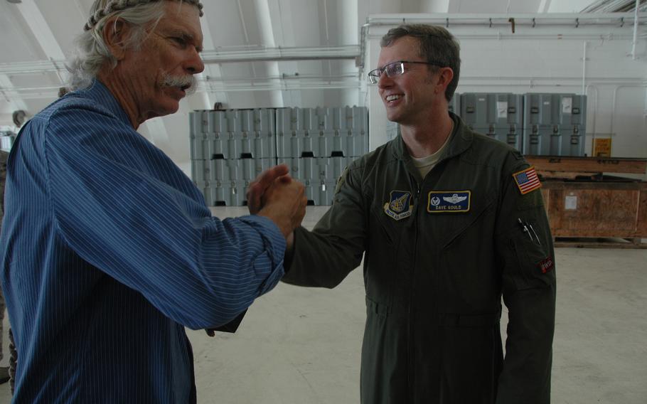 Bruce Best, left, locks hands with Col. David Gould