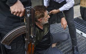 A man is arrested by security forces in Syria.