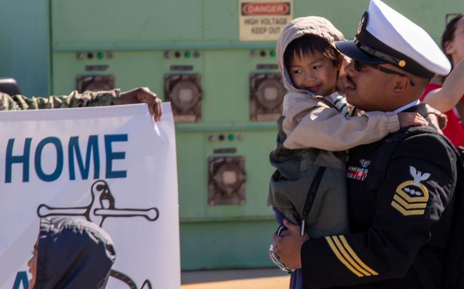 A sailor embraces a baby