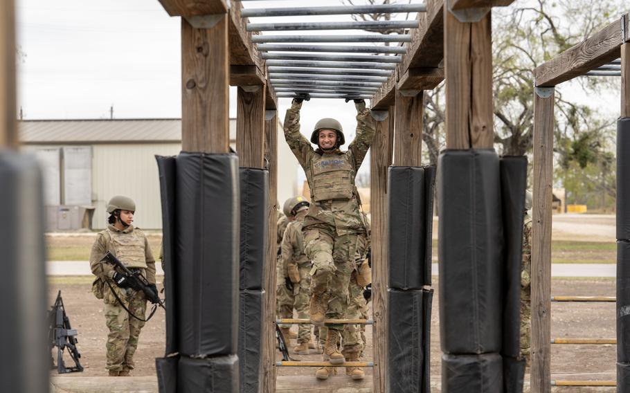 Trainee Anita Alvarez, 331st Training Squadron, hangs from the bars during the Confidence Course