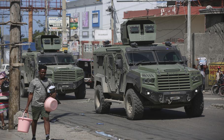 Kenyan police vehicles patrol a street as residents flee their homes to escape gang violence in the Delmas neighborhood of Port-au-Prince, Haiti, Tuesday, Feb. 25, 2025. 