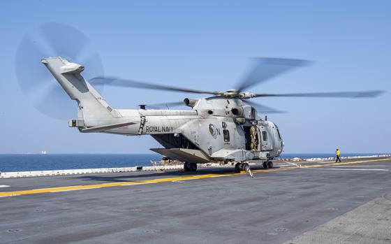 GULF OF OMAN (Nov. 8, 2021) Aviation Boatswain’s Mate (Handling) 3rd Class Alejandra Basilio signals to a Royal Navy Merlin Mk4 attached to 845 Naval Air Squadron, deployed with the Royal Navy aircraft carrier HMS Queen Elizabeth, on the flight deck of the amphibious assault ship USS Essex (LHD 2) during an interoperability exercise with the Queen Elizabeth, Nov. 8. Essex and the 11th Marine Expeditionary Unit are deployed to the U.S. 5th Fleet area of operations in support of naval operations to ensure maritime stability and security in the Central Region, connecting the Mediterranean and the Pacific through the western Indian Ocean and three strategic choke points. (U.S. Navy photo by Mass Communication Specialist 2nd Class John McGovern)