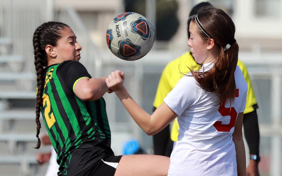 Edgren's Aliyah Torres and Kinnick's Victoria Justice try to play the ball during Saturday's DODEA-Japan girls soccer match. The Red Devils won 10-0.