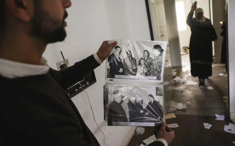 A man shows old pictures of the late Syrian President Hafez Assad.