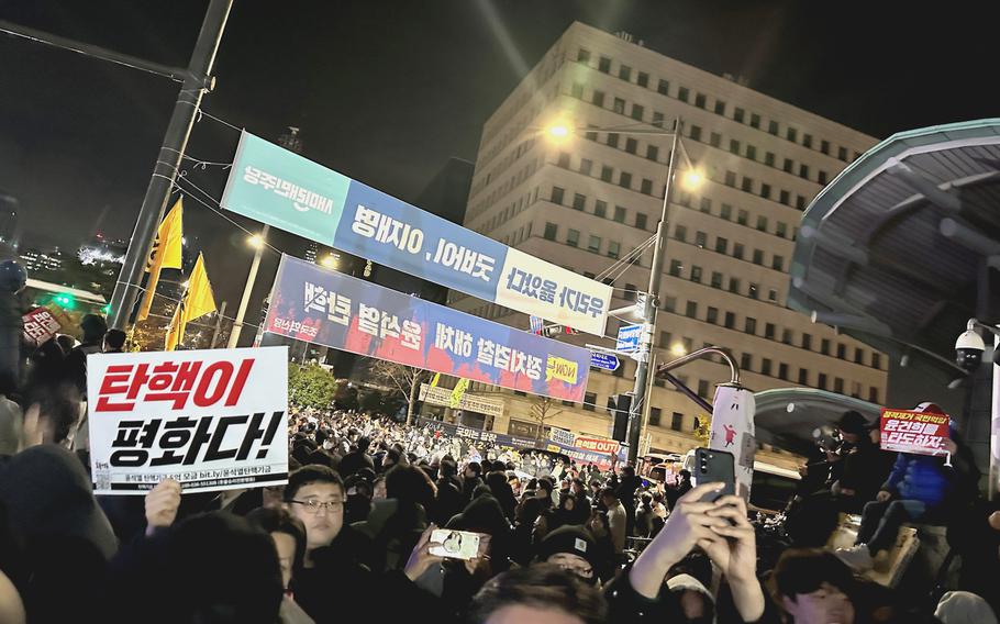 Demonstrators rally outside the gates of the National Assembly.