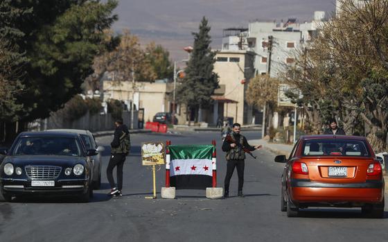 Syrian opposition fighters man a checkpoint in Damascus, Syria, Monday Dec. 9, 2024. (AP Photo/Omar Sanadiki)