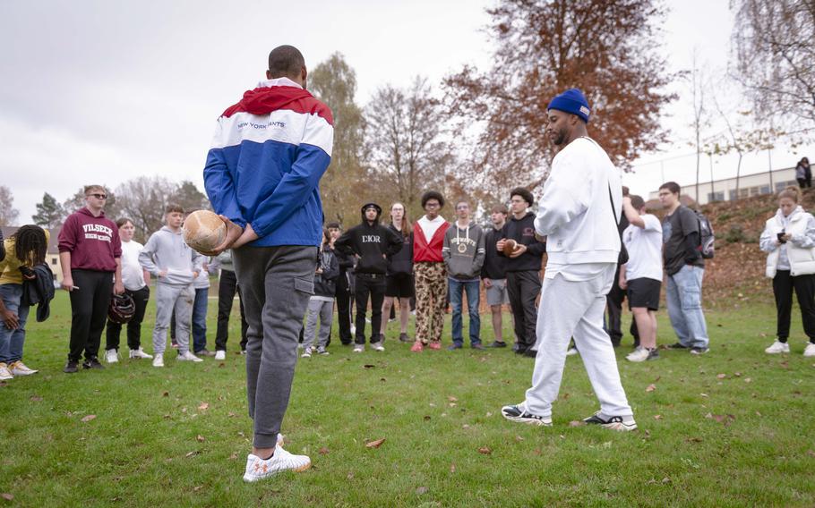 Former New York Giants players Brandon London and Victor Cruz speak to Vilseck High School students in Germany after a short football game on Thursday. The players visited the high school and elementary school on Rose Barracks prior to the Giants’ game against the Carolina Panthers on Sunday to talk to students about competition in sports and life.