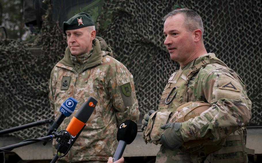 Commanders speak to into microphones about a NATO exercise.