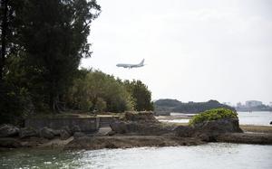  A military plane flies over Kadena Marina near Kadena Air Base, Okinawa.