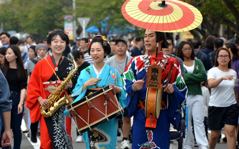 Street performers march while playing Japanese and American music at Yokosuka Naval Base.