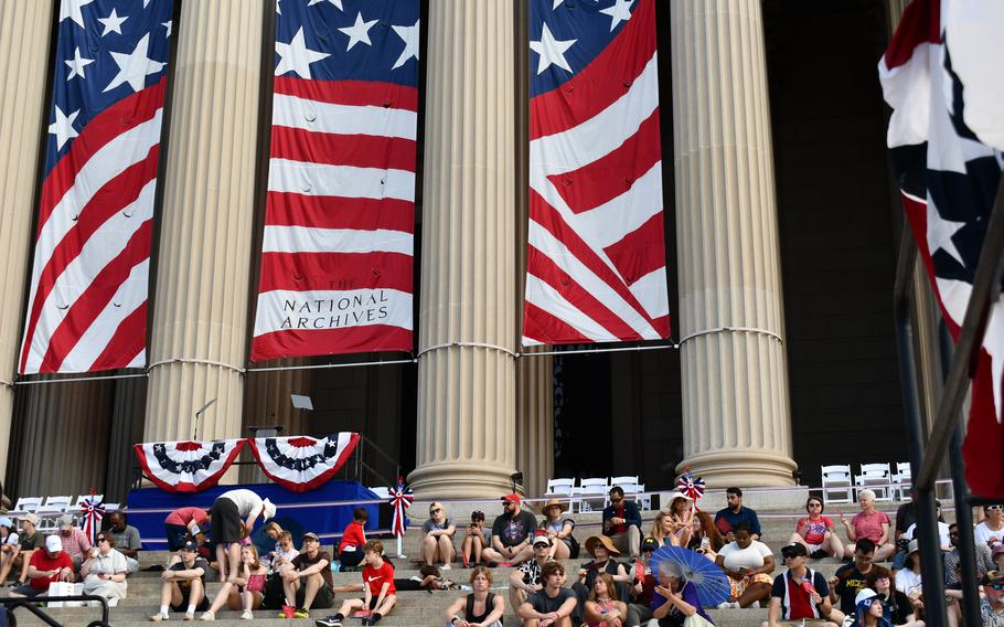 People gather on the steps of the National Archives ahead of an Independence Day event in Washington, D.C.