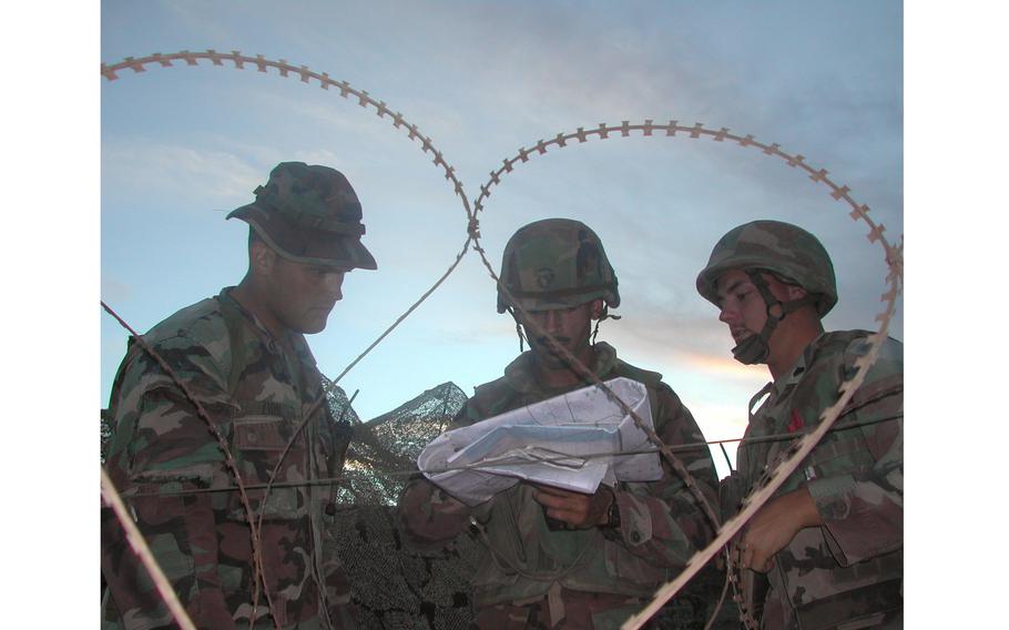 Marines seemingly framed by a heart made out of concertina wire