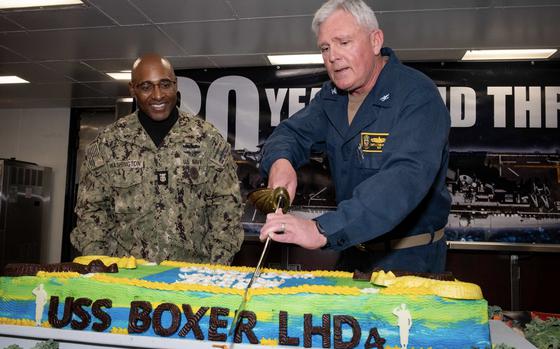 Capt. Jason Tumlinson, Wasp-class amphibious assault ship USS Boxer (LHD 4) commanding officer, and a native of Spokane, Washington, cuts a cake as Command Master Chief Benjamin Washington, also assigned to Boxer, and a native of Rochester, New York, observes during Boxer’s 30th birthday celebration on the messdecks Feb. 11, 2025. Boxer is homeported in San Diego. (U.S. Navy photo by Mass Communication Specialist Seaman Tyler Miles)