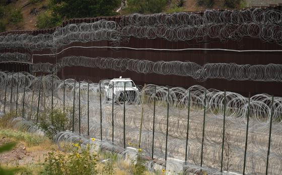 FILE - A vehicle drives along the U.S. side of the US-Mexico border wall in Nogales, Ariz., June 25, 2024. The Biden administration is making asylum restrictions at the southern border even tougher. The changes come in the middle of an election campaign where border security is a key concern for voters, and the administration is increasingly eager to show voters it's taking a hard stance. (AP Photo/Jae C. Hong, Pool, File)