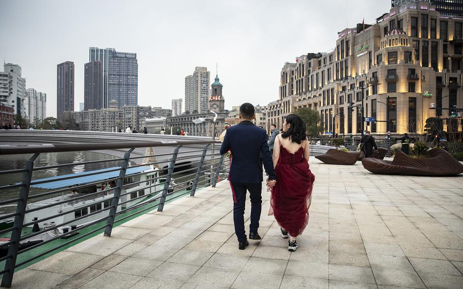 A couple’s wedding photographs are taken while walking along the Bund in Shanghai, China, on Feb. 28, 2023.