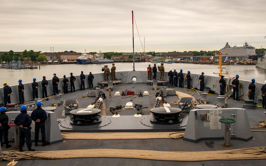 Sailors line the rails of the USS New York as it approaches the port in Kiel, Germany.