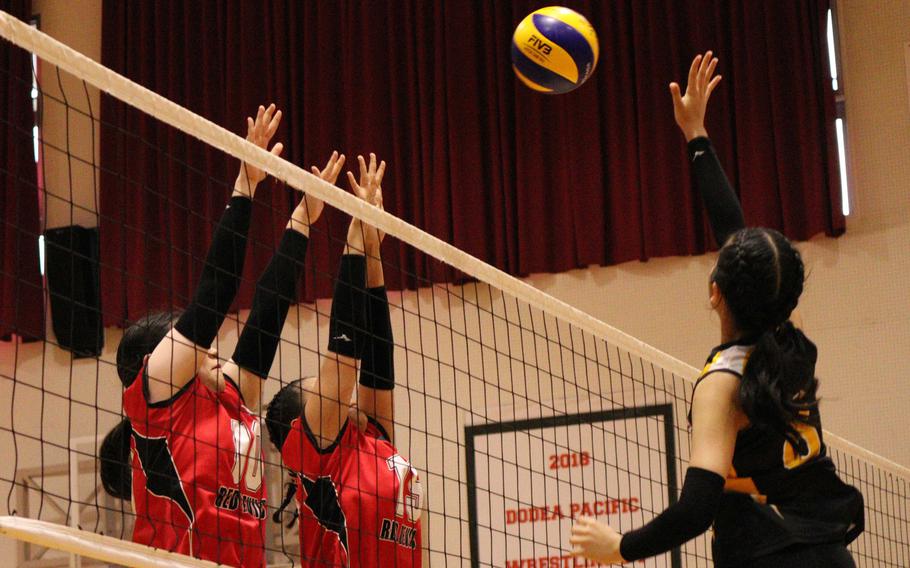 Nile C. Kinnick's Kay Kim and Leona Turner go up to block against American School In Japan's Christina Samson during Tuesday's Kanto Plain volleyball match. The Mustangs won in two sets.