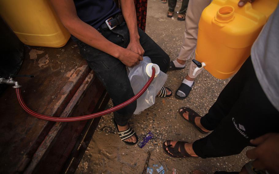 A Palestinian boy fills containers with water from a mobile tank in western Khan Younis, Gaza, on Oct. 31. 