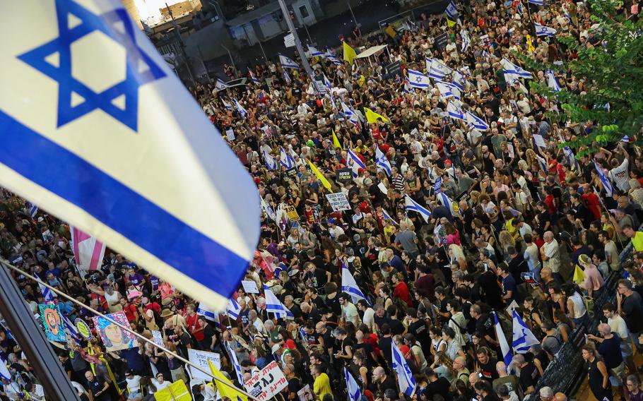 Demonstrators lift placards and flags during a protest calling for the release of Israelis held hostage by Palestinian militants in Gaza since October, in Tel Aviv on Saturday, Aug. 31, 2024.