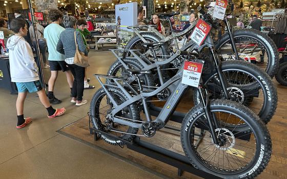 Shoppers pass by electric bicycles on display in a Cabela's sporting goods store Sunday, Dec. 8, 2024, in Lone Tree, Colo. (AP Photo/David Zalubowski)