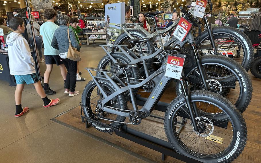 Shoppers pass by electric bicycles on display in a Cabela’s sporting goods store in Colorado.