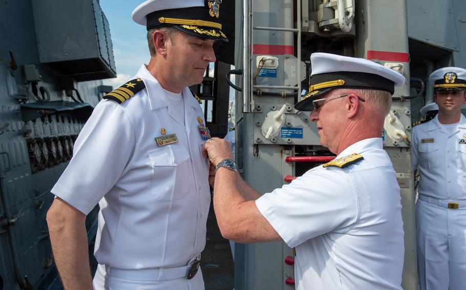 Adm. Daryl Caudle, commander presents the Bronze Star medal to CDR. Eric Blomberg